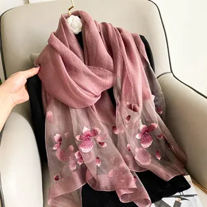 Detail of embroidered silk wool shawl with delicate floral patterns and pearl accents