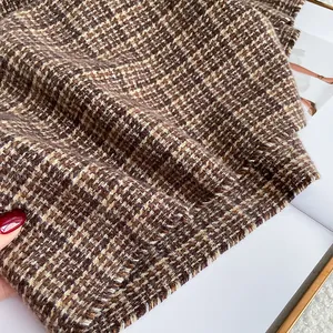 Close-up of thick brown plaid cashmere texture and detailed woven pattern of the scarf