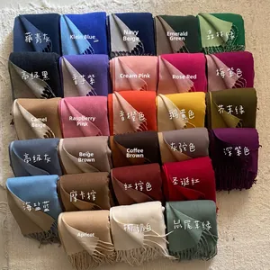Flat lay of 27 colors thick pashmina scarves with tassel edges on a soft beige background