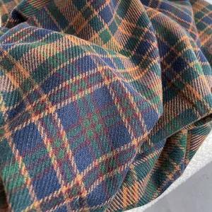 Close-up detail of soft cashmere plaid scarf fabric texture in navy and orange check
