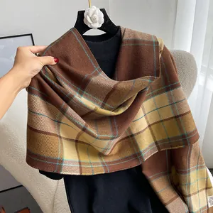 Close-up of the vintage plaid scarf texture with a white woven label on thick fabric