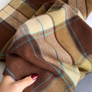 Detailed macro view of soft cashmere plaid scarf fabric in brown and blue tones
