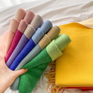 Close-up of colorful cashmere-feel scarves with fringe details in multiple vibrant hues