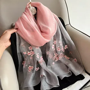 Detail of pink cherry blossom embroidery on gradient silk wool scarf fabric texture