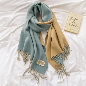 Detail of grey-blue and camel cashmere-feel scarf with tassels and sewn label