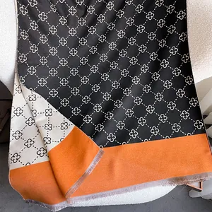 Detail view of thickened cashmere-like scarf with clover pattern and orange trim