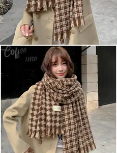 Detail of houndstooth scarf texture and fringe with model wearing warm beige wool coat