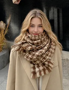 Close-up of thick houndstooth scarf with khaki tassels and soft knit texture detail