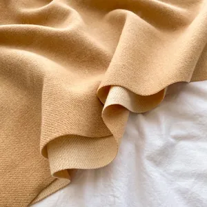 Detailed close-up of camel cashmere scarf showing thick twill weave texture and soft fabric