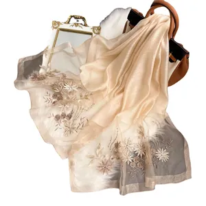 Luxurious champagne silk wool scarf with floral embroidery and sequins on soft rug