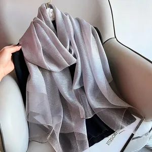 Silver silk wool shawl with metallic sheen on camellia hanger over gray sofa