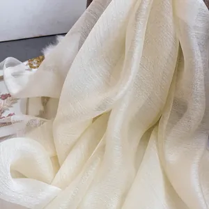 Close-up of translucent off-white silk wool scarf fabric with delicate texture and subtle pearl sheen