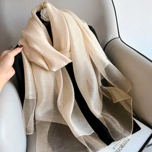 Detailed view of champagne silk scarf with subtle shimmer and elegant pleated texture