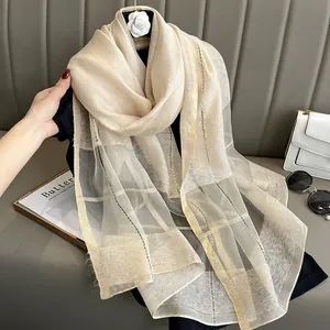 Detail of silk mohair scarf showing champagne gold metallic stripes and sheer texture