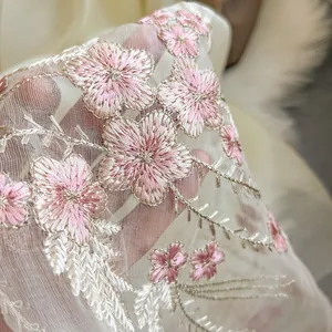 Detail of high-density pink floral embroidery on semi-transparent beige silk wool scarf