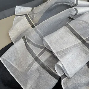 Gros plan détaillé sur la texture translucide et le motif à carreaux classique du foulard en soie