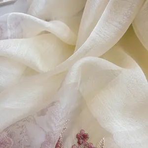 Detail of sheer beige silk wool scarf with intricate pink flower embroidery and sequins