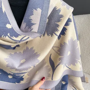 Détail du motif floral sur une écharpe épaisse en imitation cachemire beige et bleu