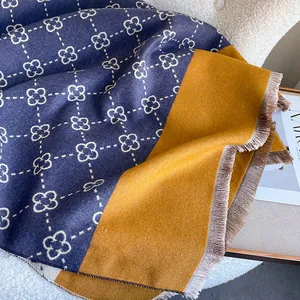 Thick navy and yellow cashmere scarf with clover pattern and fringe on boucle background
