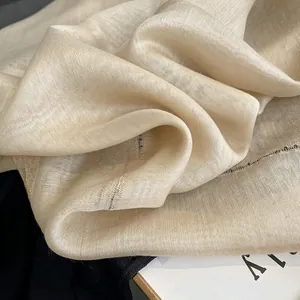 Detailed macro shot of premium champagne silk mohair fabric with subtle gold metallic threads