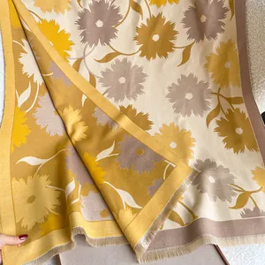 Détail macro de l'écharpe florale jaune moutarde avec franges fines et texture cachemire