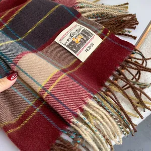 Detailed close-up of retro plaid scarf with fringes and minimalist brand label