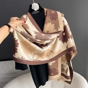 Détail d'une écharpe fleurie en imitation cachemire aux tons bruns et bords frangés