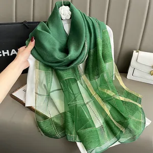 Detailed macro shot of dark green silk mohair scarf with gold check woven pattern
