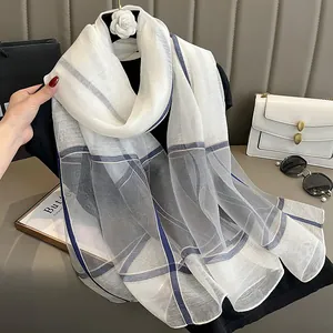 Écharpe en soie à carreaux classiques blanc crème et bleu marine suspendue comme un châle