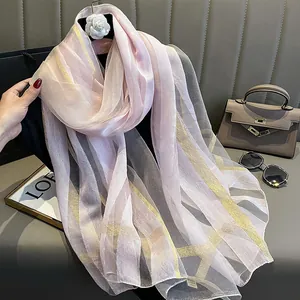 Écharpe élégante en soie rose avec rayures dorées et une texture douce semi-transparente