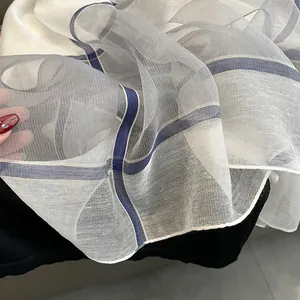Gros plan d'une écharpe en soie à carreaux montrant la texture et la transparence