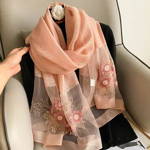 Gros plan d'une écharpe en soie rose élégante avec broderies florales détaillées