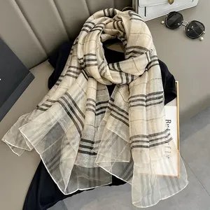 Detail of classic plaid silk shawl featuring fine beige and khaki checkered texture