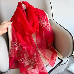 Detailed embroidery on a lightweight red silk wool scarf with elegant floral patterns