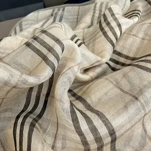 Close-up of silk scarf fabric showing classic plaid pattern and metallic gold thread detail