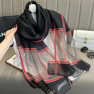 Détail d'un foulard en soie à carreaux classiques avec motif rouge et gris fin