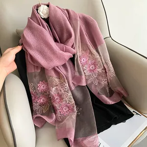 Détail d'un châle en laine de soie avec broderie florale délicate et paillettes brillantes