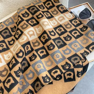 Détail d'une écharpe en maille douce à motifs de chat et damier tricolore
