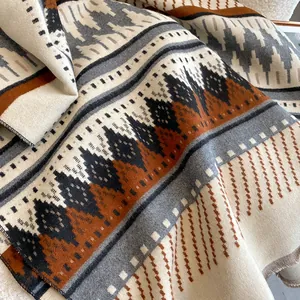 Detail of bohemian geometric shawl with thick texture and fringe on sherpa fabric