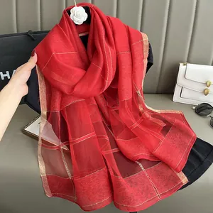 Detail of red silk mohair scarf featuring gold metallic thread in a classic plaid pattern