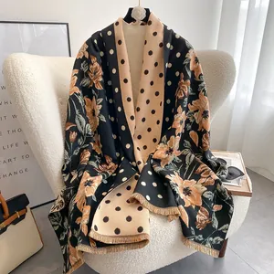 Detailed view of thick floral and polka dot cashmere-like shawl with fringed edges
