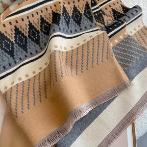 Macro shot of thick bohemian scarf with geometric diamond patterns and tassel details