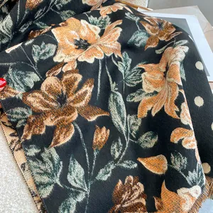 Detailed close-up of ethnic floral pashmina scarf with fringe and warm knitted texture