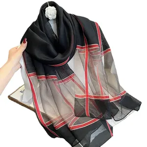 Écharpe en soie à carreaux noirs avec rayures rouges et broche fleur de camélia blanche