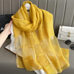 Close-up of bright yellow silk mohair scarf with golden thread and subtle plaid texture