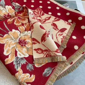 Close-up of thick double-sided jacquard shawl with floral patterns and fringe details