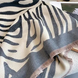 Dettaglio della sciarpa spessa zebrata con morbida trama in cashmere e frange rifinite