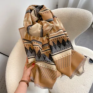 Detail shot of bohemian geometric scarf with earth tone patterns and soft fringe edges