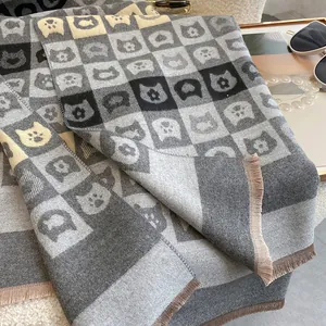Détail d'écharpe douce à motif damier avec motifs de chats et longues franges élégantes