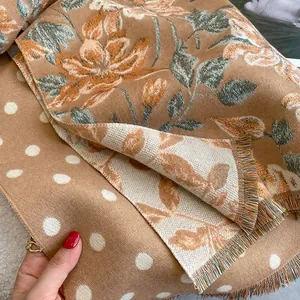 Detail of floral and polka dot cashmere shawl with fringe trim and soft fabric texture
